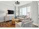 Cozy living room with hardwood floors, a comfortable sofa, and a large window providing natural light at 11724 Easthampton Cir, Charlotte, NC 28277