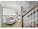 Bright loft area features a cozy armchair, built-in shelving, and a staircase with white risers and a wooden handrail at 11724 Easthampton Cir, Charlotte, NC 28277