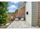 Patio features stone pavers, garden decor, and two chaise lounges with blue pillows at 11724 Easthampton Cir, Charlotte, NC 28277