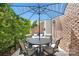 Cozy patio area featuring a round table with seating, a blue striped umbrella, and charming brick accents at 11724 Easthampton Cir, Charlotte, NC 28277