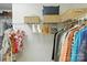 Walk-in closet with built-in shelves for folded clothes, hanging space, and storage baskets at 11724 Easthampton Cir, Charlotte, NC 28277