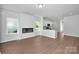 Open living space with a fireplace, hardwood floors, and a view of the modern kitchen at 1225 Langston Ln, Salisbury, NC 28144