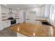 Open kitchen layout with white cabinets, wooden countertops, and stainless steel appliances at 132 Kennedy Ave, Kannapolis, NC 28083