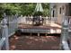 A wooden back deck with a table and chairs, white railing, and a green umbrella for a relaxing outdoor space at 1325 Lee Lynn Dr # 7 Part Of 6, Albemarle, NC 28001