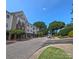 Low-angle view of a condo building from the street with mature trees and blue sky at 1410 4Th Street Nw Dr # 303, Hickory, NC 28601