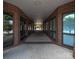 An outdoor hallway lined with brick columns and windows looking out onto green spaces at 1410 4Th Street Nw Dr # 303, Hickory, NC 28601