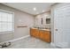 Bathroom with double vanity, tile floor, and natural light from window at 14411 Eastfield Rd, Huntersville, NC 28078
