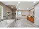Modern bathroom featuring a soaking tub, glass shower, double vanity, and ceramic tile flooring at 14411 Eastfield Rd, Huntersville, NC 28078