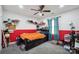 Modern bedroom featuring red and white walls, ceiling fan and twin bed with luggage at 14411 Eastfield Rd, Huntersville, NC 28078