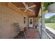 Relaxing covered porch with rocking chairs, ceiling fan, and brick accents at 14411 Eastfield Rd, Huntersville, NC 28078