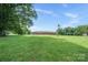 Expansive lawn with a well-maintained single-story brick home, complete with inviting front porch and serene landscaping at 14411 Eastfield Rd, Huntersville, NC 28078