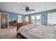 Bright primary bedroom with a ceiling fan, desk and French doors leading to outdoor living at 14411 Eastfield Rd, Huntersville, NC 28078