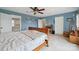 A bright main bedroom featuring a ceiling fan, wall decor and multiple entry doors at 14411 Eastfield Rd, Huntersville, NC 28078