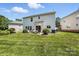 A large backyard with green grass, a patio, and landscaping bordering the house at 15508 Normans Landing Dr, Charlotte, NC 28273