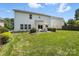 Expansive backyard with a well-kept lawn, patio, and surrounding greenery at 15508 Normans Landing Dr, Charlotte, NC 28273