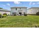 Lush backyard featuring green grass, a patio with seating, and home exterior at 15508 Normans Landing Dr, Charlotte, NC 28273