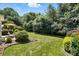 Spacious backyard featuring a lush lawn, mature trees, and a patio area at 15508 Normans Landing Dr, Charlotte, NC 28273