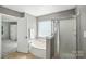 Primary bathroom with stand-up shower, soaking tub, and large window for natural light at 15508 Normans Landing Dr, Charlotte, NC 28273