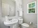 Cozy half bathroom featuring a pedestal sink, toilet, and bright window at 15508 Normans Landing Dr, Charlotte, NC 28273