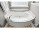 Close-up view of a soaking tub with chrome fixtures and a bright window at 15508 Normans Landing Dr, Charlotte, NC 28273