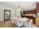 Dining room featuring a modern light fixture, white table and chairs, cherry cabinets at 15508 Normans Landing Dr, Charlotte, NC 28273