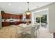 Well-equipped kitchen with cherry cabinets, tile backsplash, and a dining area with patio access at 15508 Normans Landing Dr, Charlotte, NC 28273