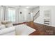 Spacious living area with hardwood floors, white walls, and staircase, creating a bright and open atmosphere at 15508 Normans Landing Dr, Charlotte, NC 28273