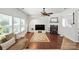 Bright living room featuring hardwood floors, a fireplace, and large windows creating a comfortable space at 15508 Normans Landing Dr, Charlotte, NC 28273