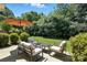 Relaxing backyard patio featuring cushioned seating, umbrella, and lush green landscaping at 15508 Normans Landing Dr, Charlotte, NC 28273