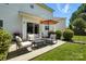 Well-maintained patio with seating, umbrella, and grill outside the sliding glass door at 15508 Normans Landing Dr, Charlotte, NC 28273