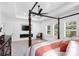 Bedroom featuring a four-poster bed, a fireplace, and large windows with natural light at 15818 Sparrowridge Ct, Charlotte, NC 28278