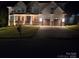 Exterior view of home at night with a beautifully lit front porch and well-manicured lawn at 15818 Sparrowridge Ct, Charlotte, NC 28278