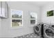 Clean laundry room with modern washer and dryer, stylish tile floor, and bright windows at 15818 Sparrowridge Ct, Charlotte, NC 28278