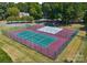 Aerial view of tennis and basketball courts surrounded by lush greenery and tall shade trees at 15818 Sparrowridge Ct, Charlotte, NC 28278
