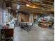 Unfinished basement with a wooden workbench, concrete floor, and some storage and utility areas at 1764 Pipers Ridge Nw Cir, Conover, NC 28613