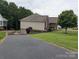Back of home showing the driveway leading to a downstairs garage and well-kept lawn and landscaping at 1764 Pipers Ridge Nw Cir, Conover, NC 28613
