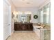 A full bathroom featuring double sinks, dark wood cabinets, garden tub, and granite countertops at 2005 Arbor Hills Dr, Indian Trail, NC 28079