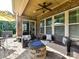 Well-appointed covered patio featuring comfortable seating around a fire pit with a view of the backyard at 2005 Arbor Hills Dr, Indian Trail, NC 28079