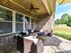 Charming brick patio with a cozy seating arrangement around a fire pit and outdoor lighting for evening ambiance at 2005 Arbor Hills Dr, Indian Trail, NC 28079