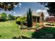 Landscaped backyard featuring lush green grass, mature trees and plantings, and a fence at 225 Northchase Dr, Concord, NC 28027