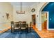 Formal dining room featuring modern chandelier, hardwood floors, and access to the kitchen at 225 Northchase Dr, Concord, NC 28027