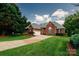 Charming all-brick home featuring a two-car garage, manicured lawn, and mature trees at 225 Northchase Dr, Concord, NC 28027