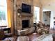 Comfortable living room with stone fireplace, mounted TV, and plush armchairs near natural light at 3022 Trace Meadow Ct, York, SC 29745