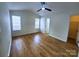 Bright bedroom featuring wood flooring, a ceiling fan, and two windows for natural light at 3106 Faircroft Way, Monroe, NC 28110