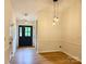 Inviting entryway featuring modern lighting, wood-look floors, and a stylish black front door at 3106 Faircroft Way, Monroe, NC 28110