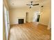 Open-concept living room with a fireplace, modern ceiling fan, and wood-look floors flowing throughout at 3106 Faircroft Way, Monroe, NC 28110