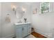 Charming powder room with a light blue vanity, decorative sconces, and wainscoting at 319 Catawba Ave, Rock Hill, SC 29730