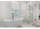 Bright bathroom with a freestanding tub, glass shower, and natural light from the window at 319 Catawba Ave, Rock Hill, SC 29730