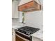 Close up of stainless steel range and custom vent hood, with marble countertops and white tile backsplash at 319 Catawba Ave, Rock Hill, SC 29730