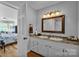 Well-lit bathroom featuring a double vanity, tiled backsplash, and a view into the bedroom at 408 Camelot Dr, Salisbury, NC 28144